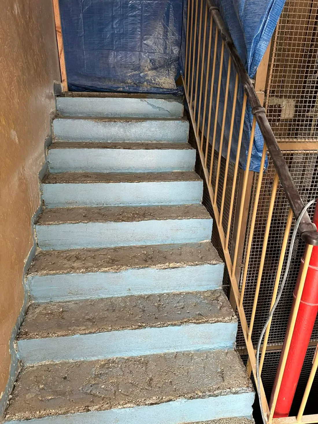 Staré betonové schodiště s odlupující se barvou před rekonstrukcí